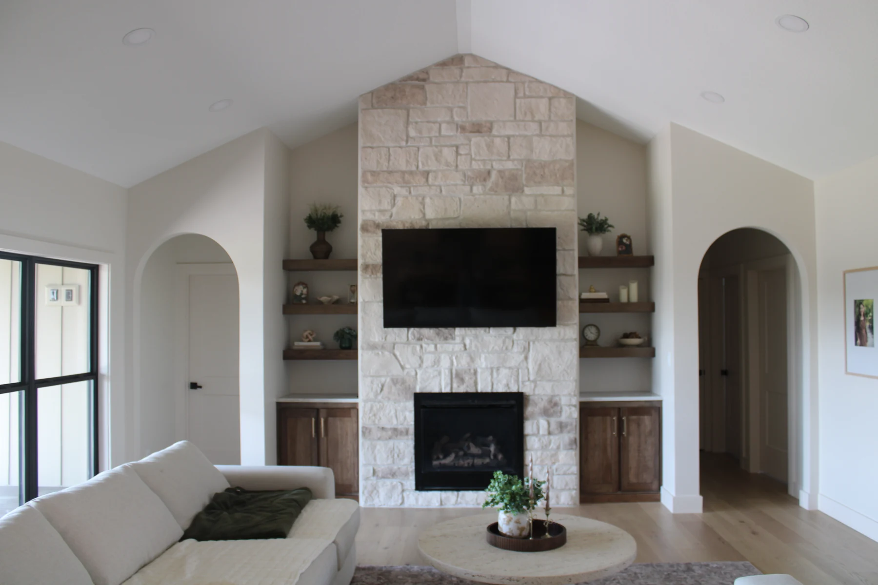 Arched openings and a stone fireplace give this living space its character.